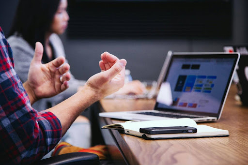 Person gesturing during a business meeting.